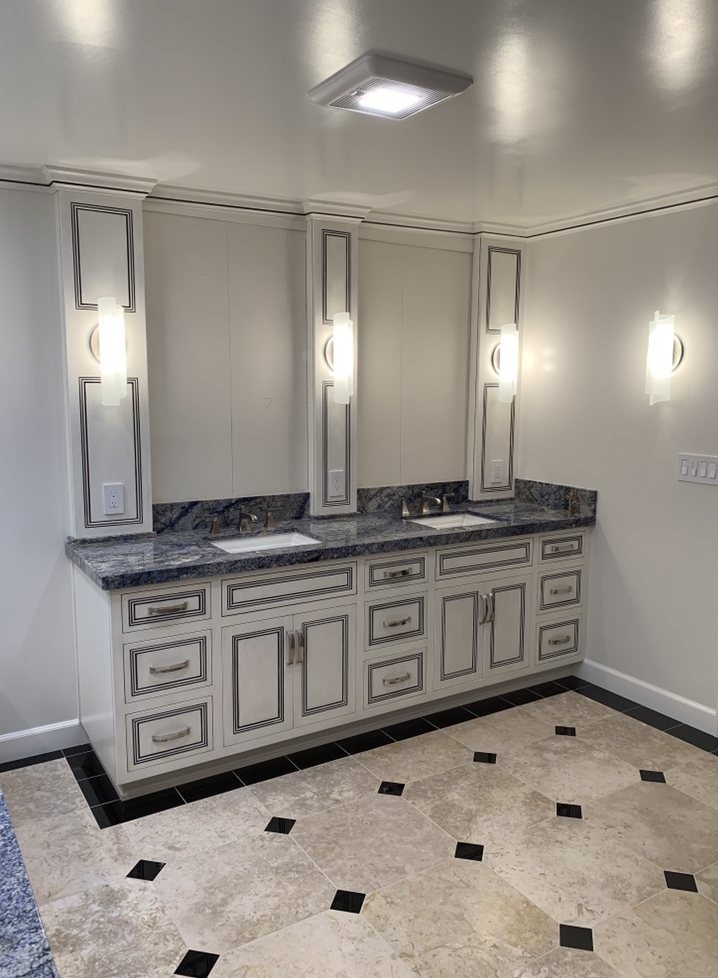 bathroom photo with cabinets in blak and white and granite top