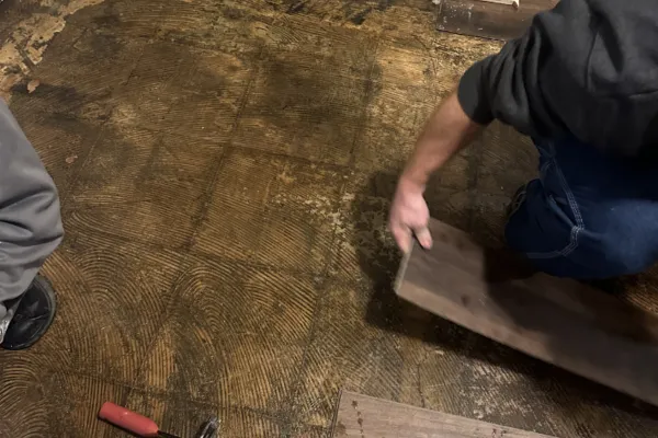 Water damaged flooring being removed during home restoration