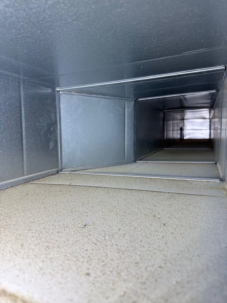 Close-up view of the clean interior of a rectangular galvanized metal HVAC air duct.