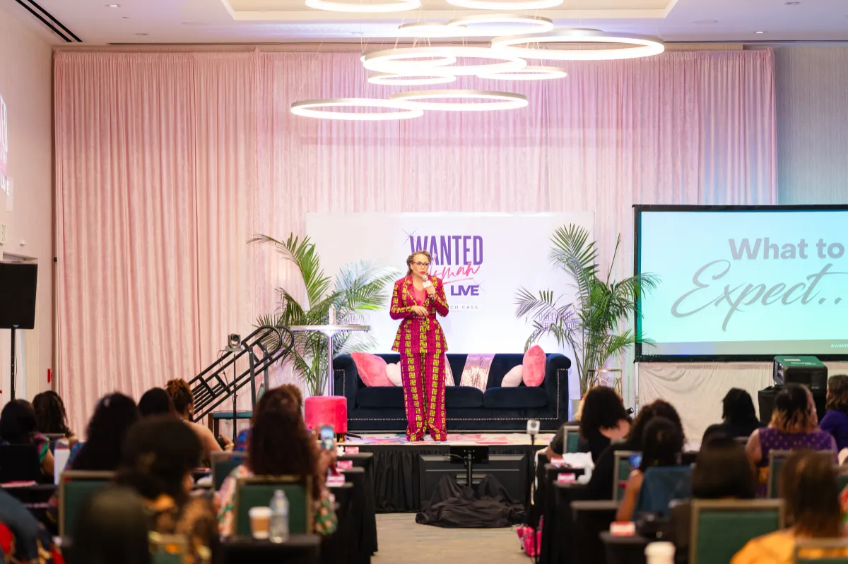 Coach Cass speaking on stage at dating event for women