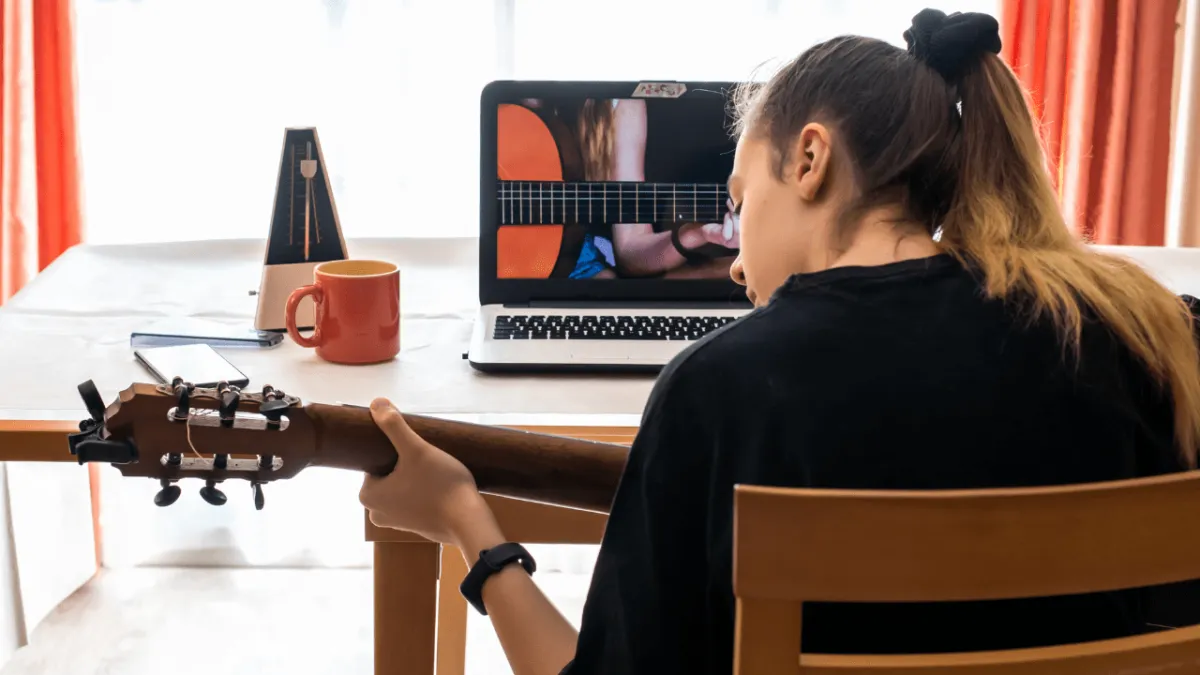 A student practicing guitar at home