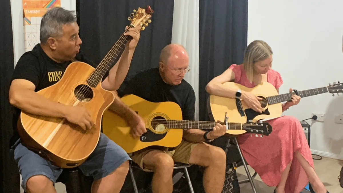 Gold Coast guitar teacher running a small group lesson for adults