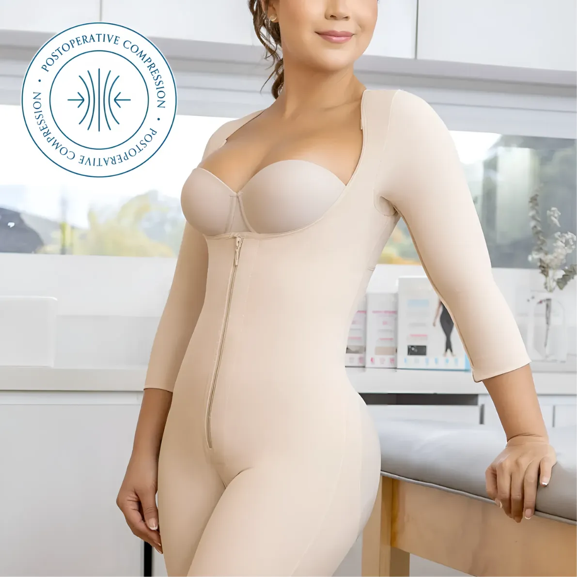 ella body fajas: Woman wearing beige full-body postoperative compression garment with zipper closure and three-quarter sleeves in clinical setting
