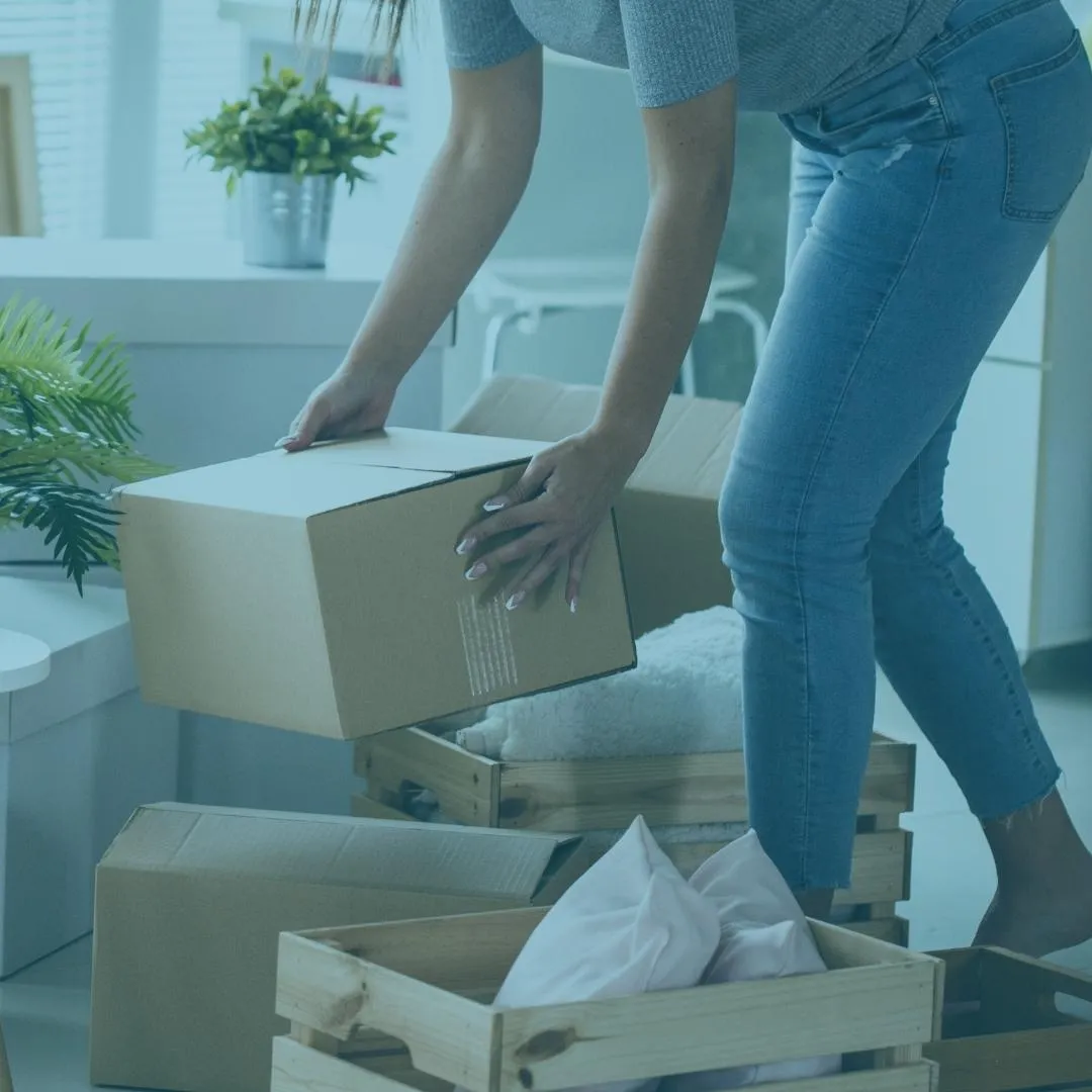 Person organizing with boxes and wooden crates, demonstrating ADHD-friendly decluttering techniques for professional organizers.