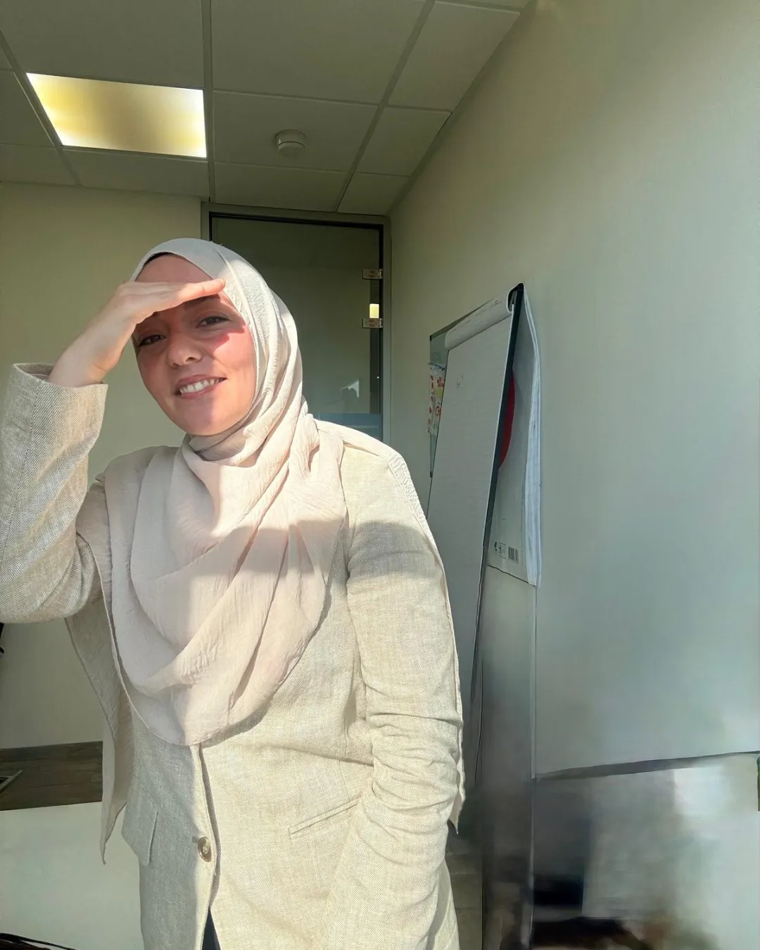 A single Turkish woman, aged around 30, with a gentle smile and relaxed posture, is isolated on a transparent background. She wears a light, flowing blouse in soft pastel colors. The lighting is natural and warm, emphasizing her calm, approachable demeanor. No background or props are present.