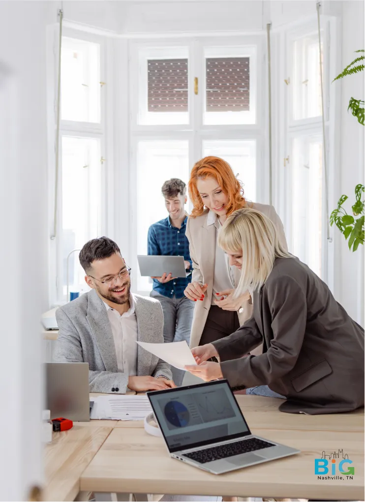 Office staff helping each other and smiling while discussing items