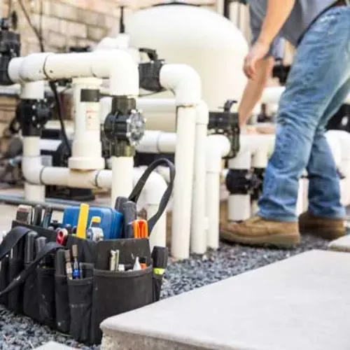 "Pool repair technician servicing equipment, ensuring efficient operation for clean and properly maintained swimming pool water."