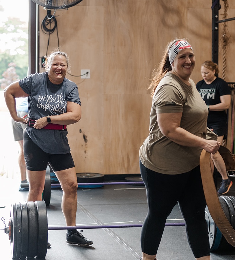 topless man in black shorts carrying black dumbbell