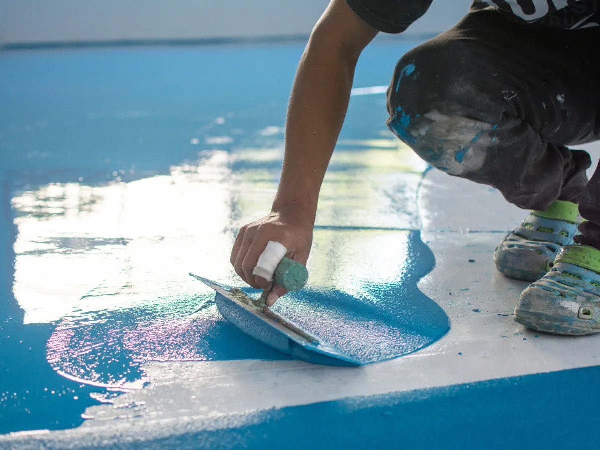 a technician applying epoxy floor color