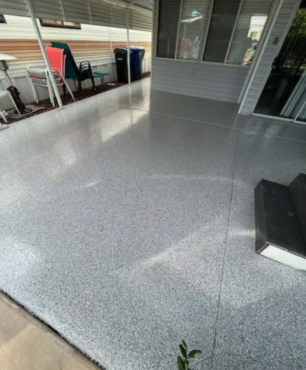 Outdoor patio epoxy floor coating with flake texture and clean finish around the home exterior.