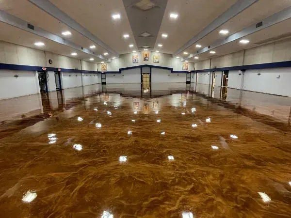 Large commercial building epoxy floor coating with high-gloss finish and reflective lighting across the floor.