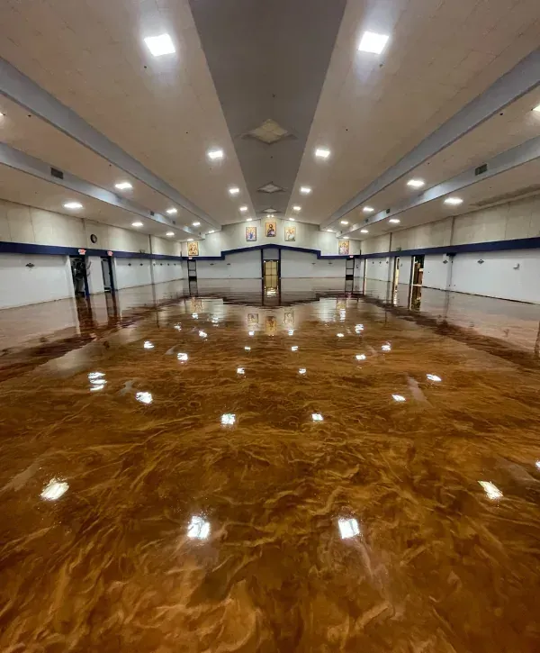 Large commercial building epoxy floor coating with high-gloss finish and reflective lighting across the floor.
