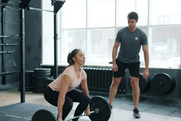 Entrenador personal guiando a un cliente en un gimnasio en Santiago de Chile