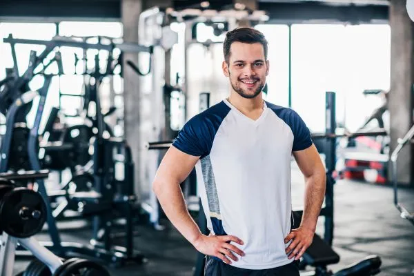 Entrenador personal trabajando con un cliente en una sala de musculación en México