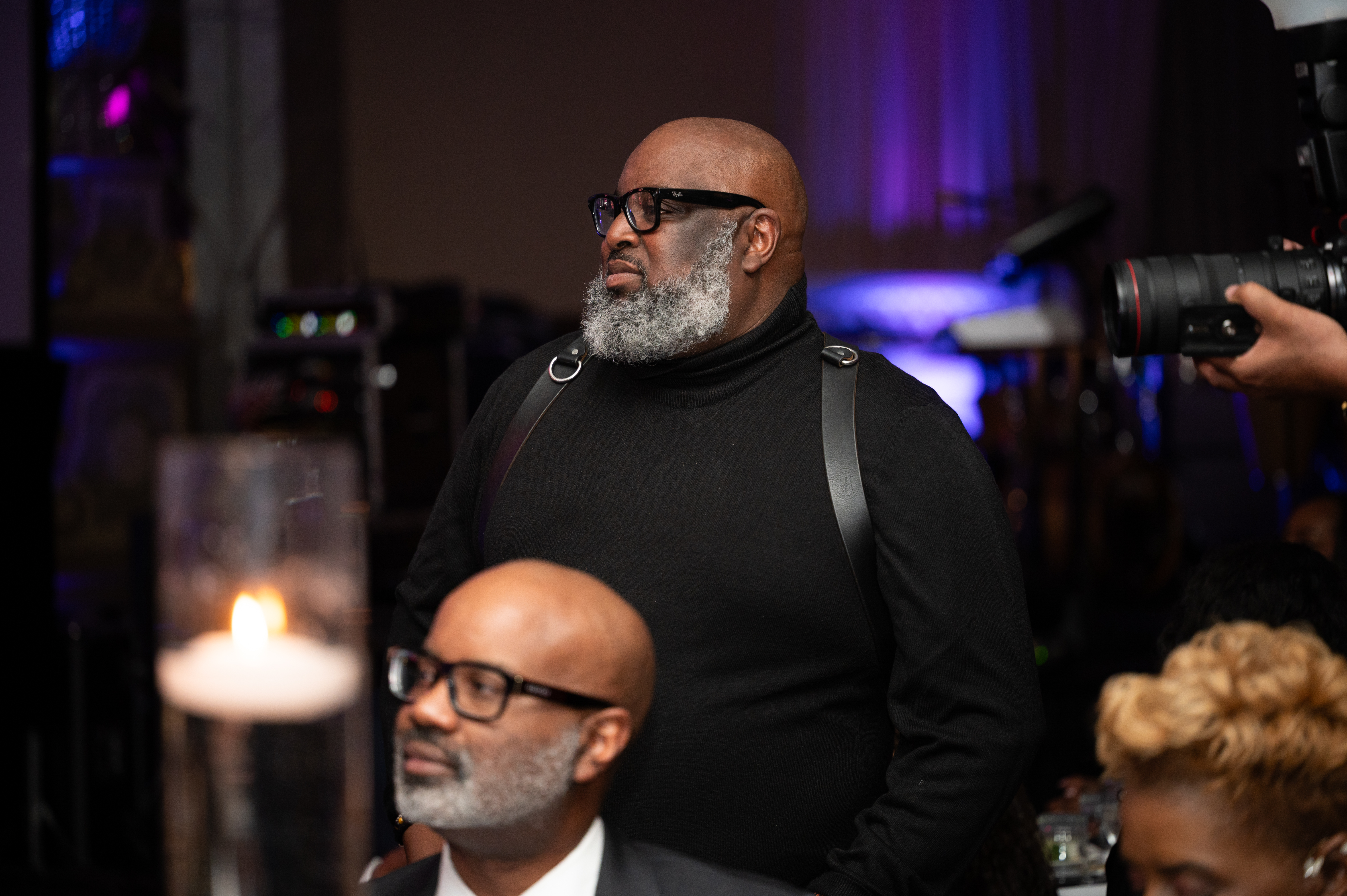 A professional event photographer capturing candid moments at a lively business conference, with diverse attendees in the background, modern lighting, and a dynamic composition emphasizing action and engagement.