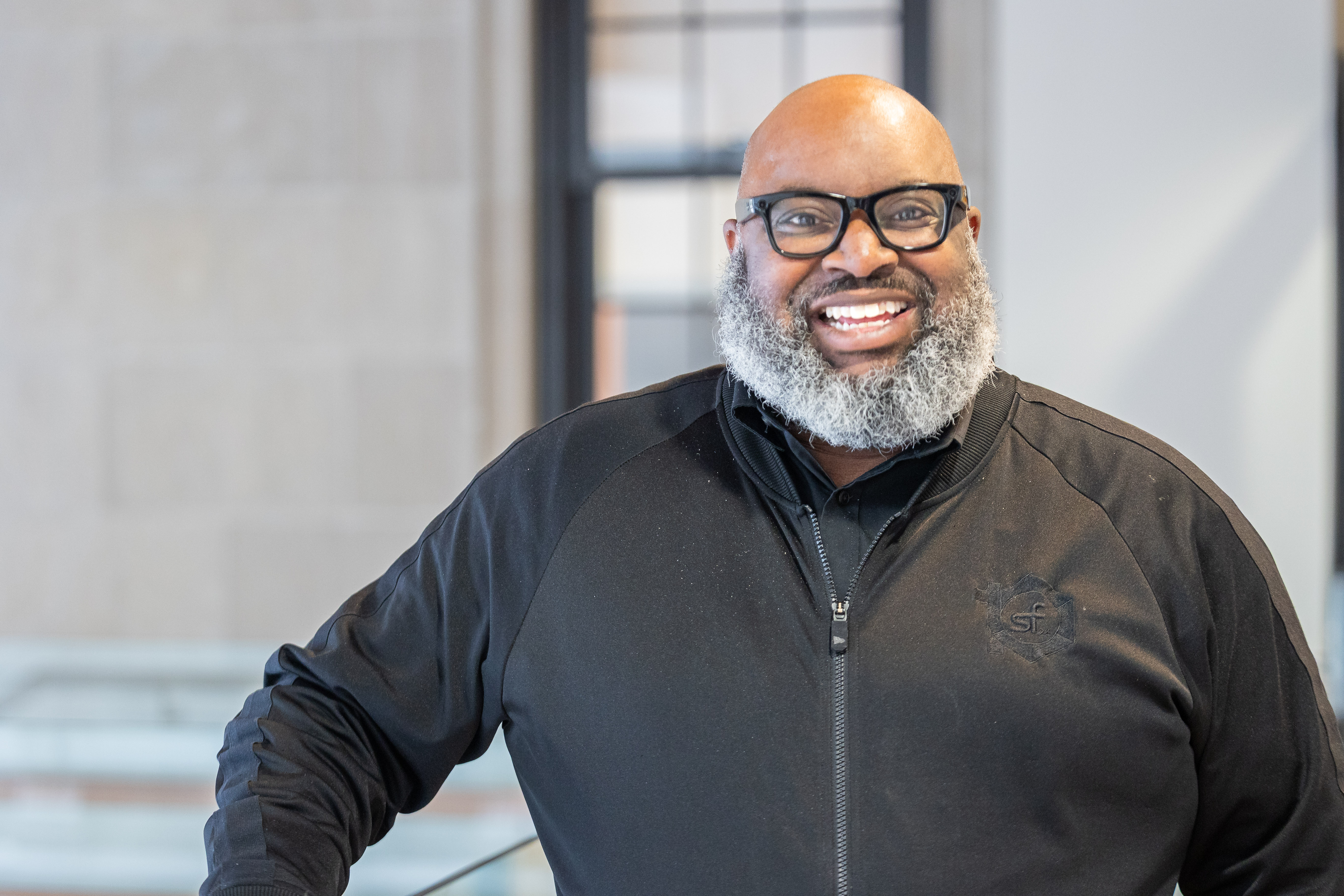 A diverse team of photography and business experts gathered in a bright studio, smiling and collaborating over a table with cameras, laptops, and notes, representing expertise and approachability.