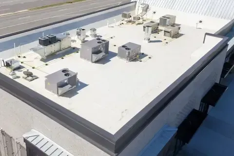 White flat roof with multiple rooftop HVAC units after commercial membrane installation