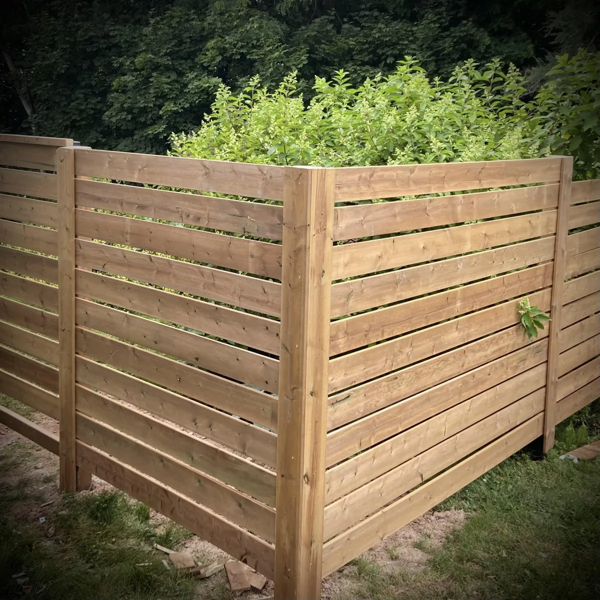 Privacy fence installation in Fredericton backyard with wood panels