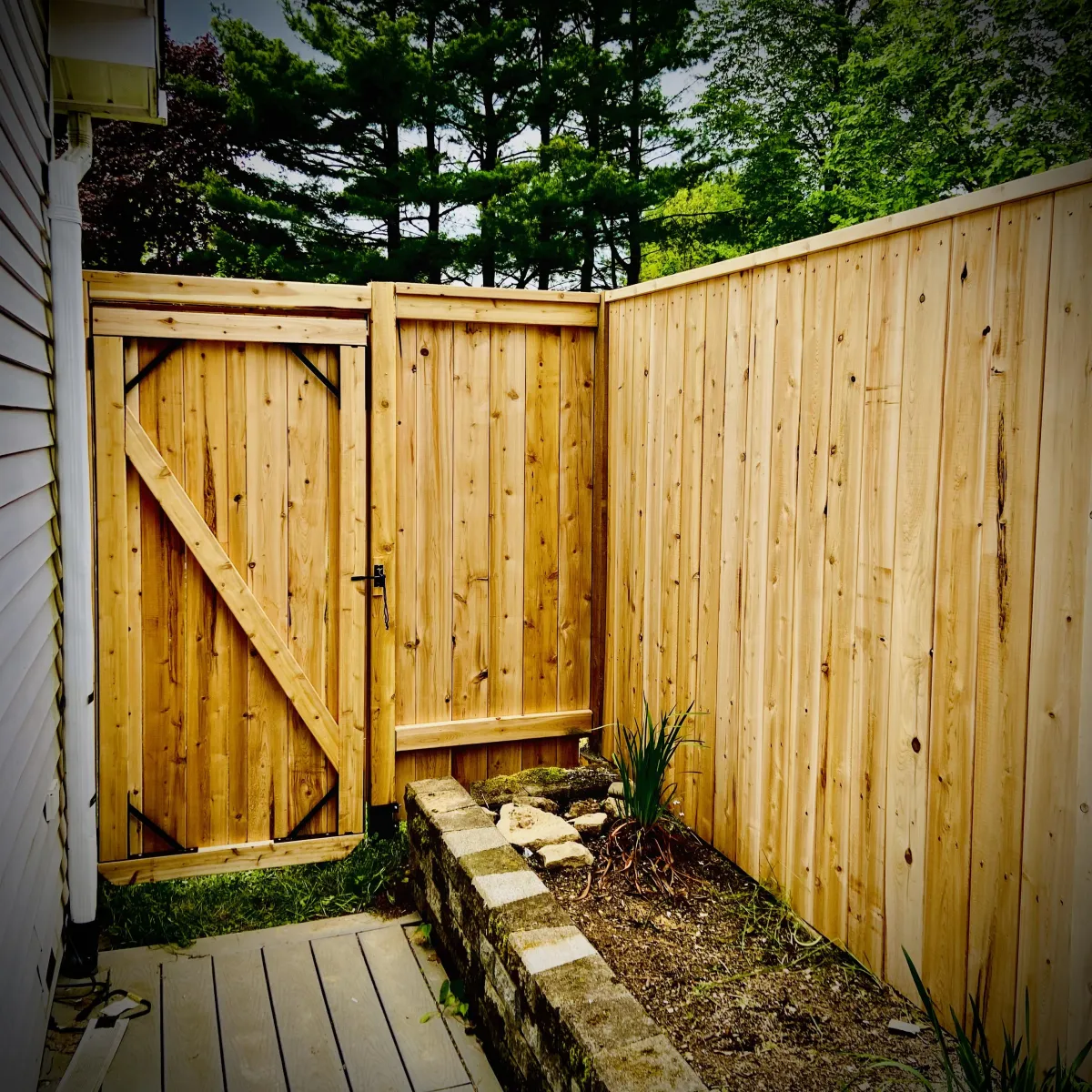 Privacy fence installation in Fredericton backyard with wood panels