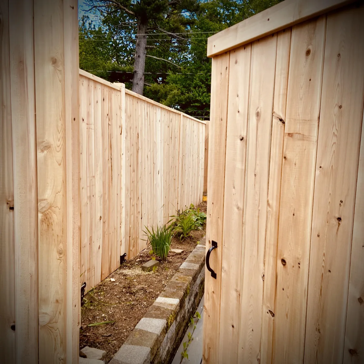 Privacy fence installation in Fredericton backyard with wood panels
