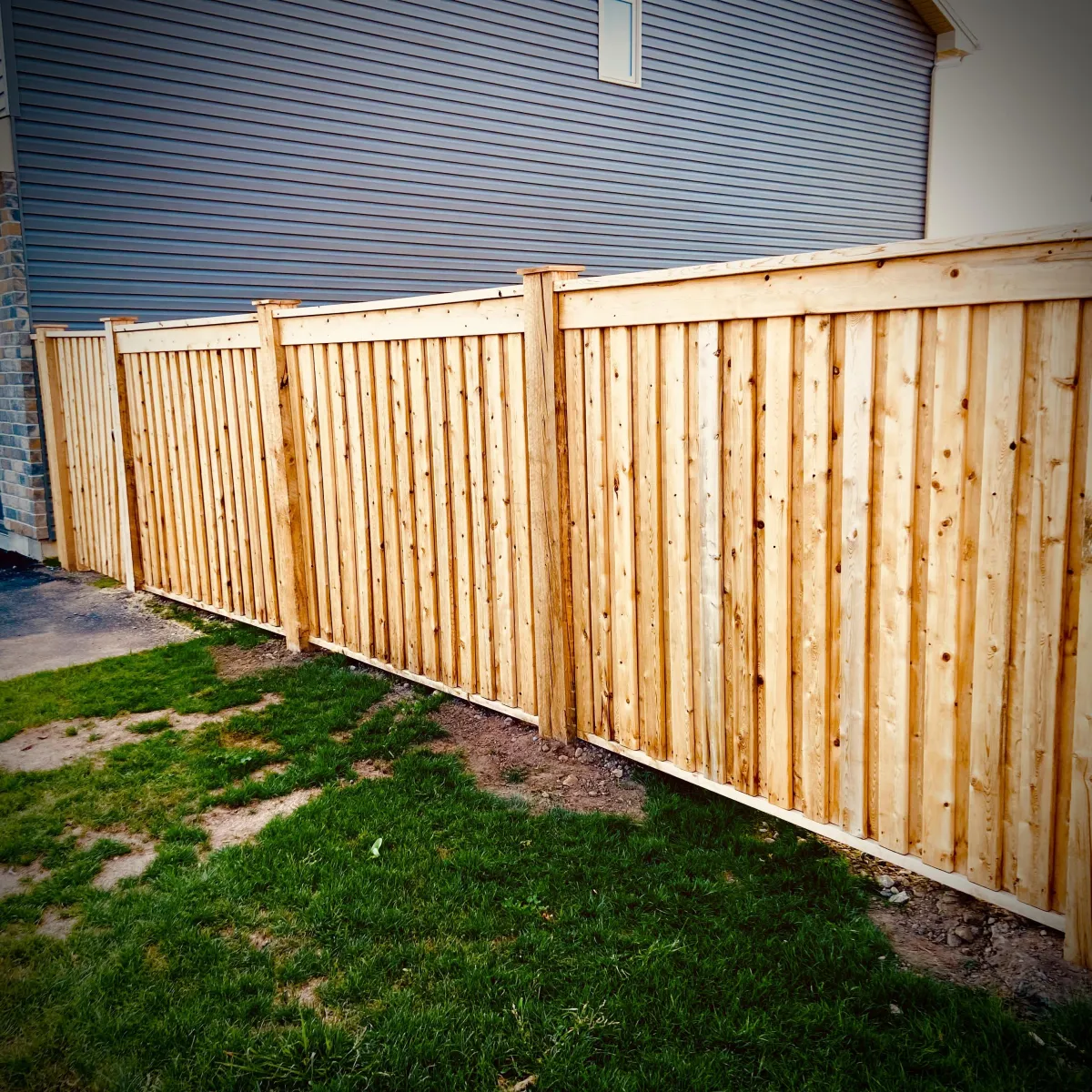 Privacy fence installation in Fredericton backyard with wood panels