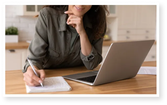 woman-with-laptop-writing-in-notebook