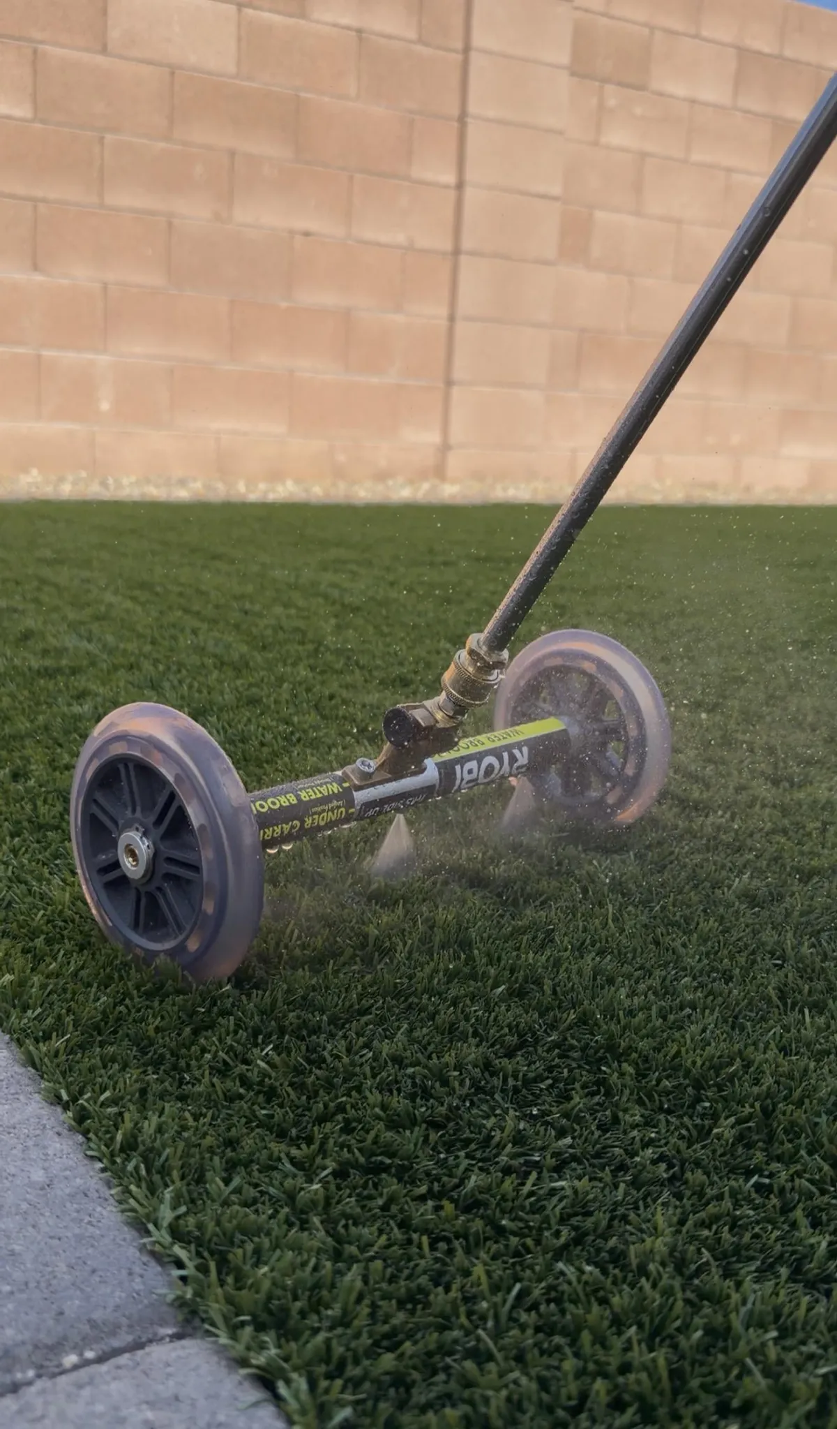 High-pressure turf rinse with water broom during deep artificial grass cleaning in Tucson