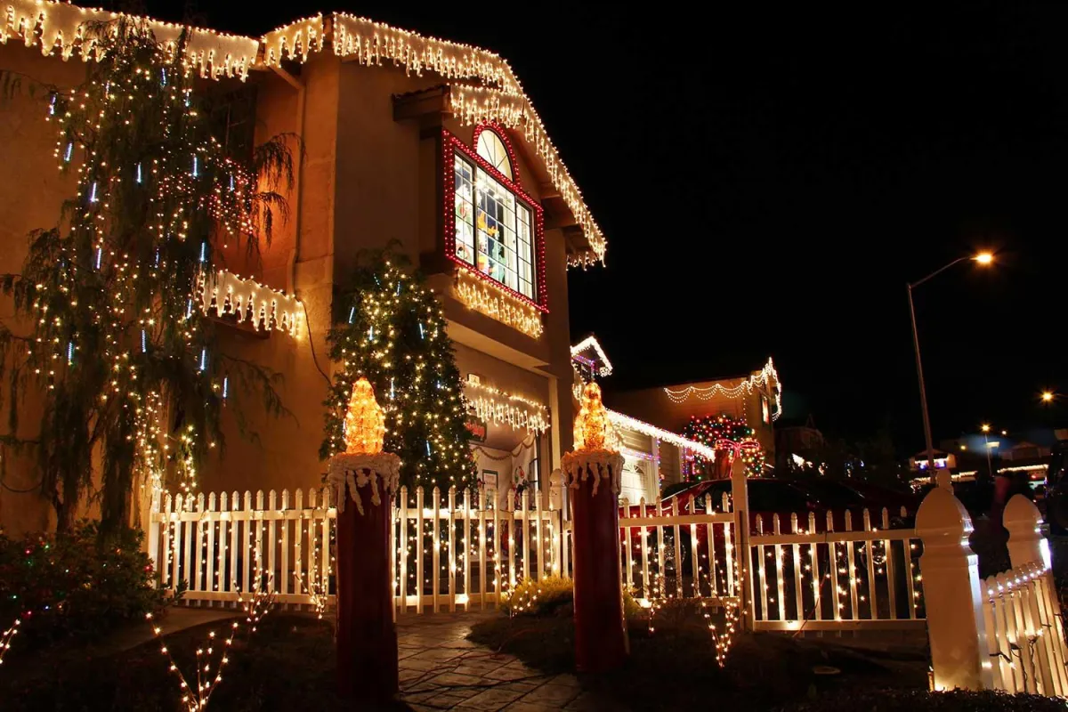 Professional Christmas light installation on a two-story home with energy-efficient LED lights, holiday decorations, and safe outdoor setup