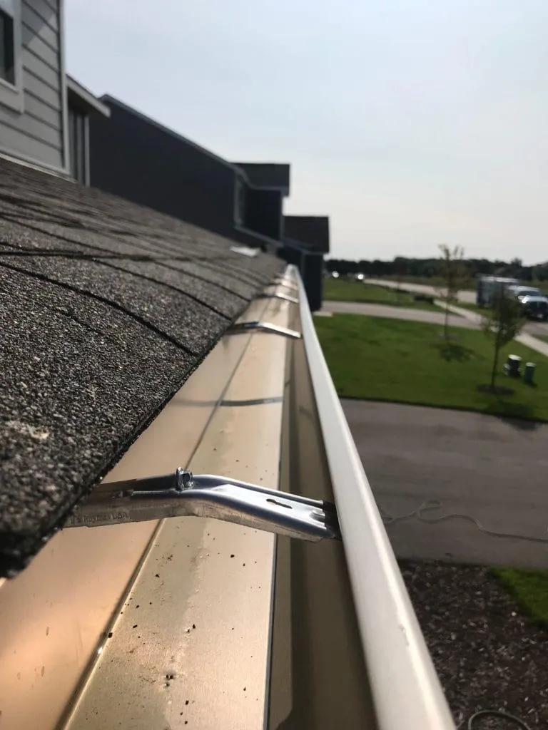 a newly installed gutter on a shingle roofing