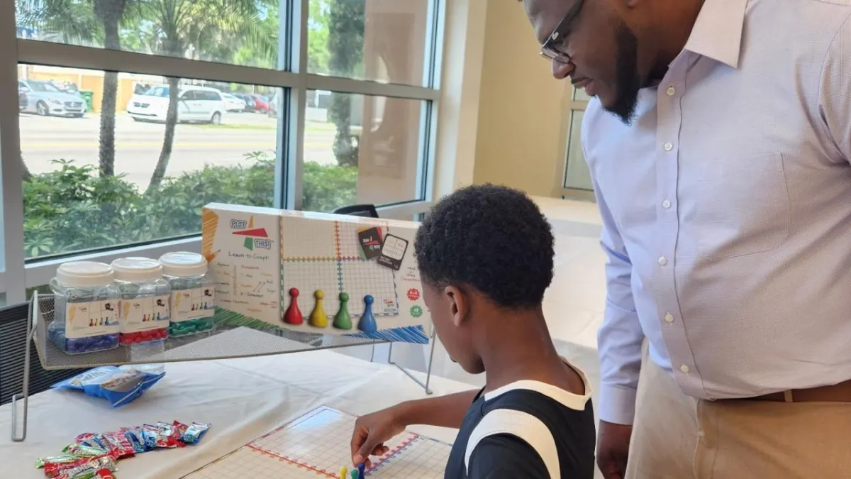 Parent guiding child while using the Plot This! graphing manipulatives set
