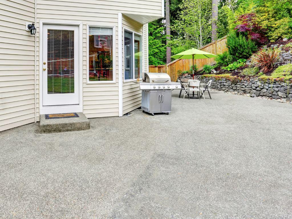 Backyard concrete patio with decorative border design