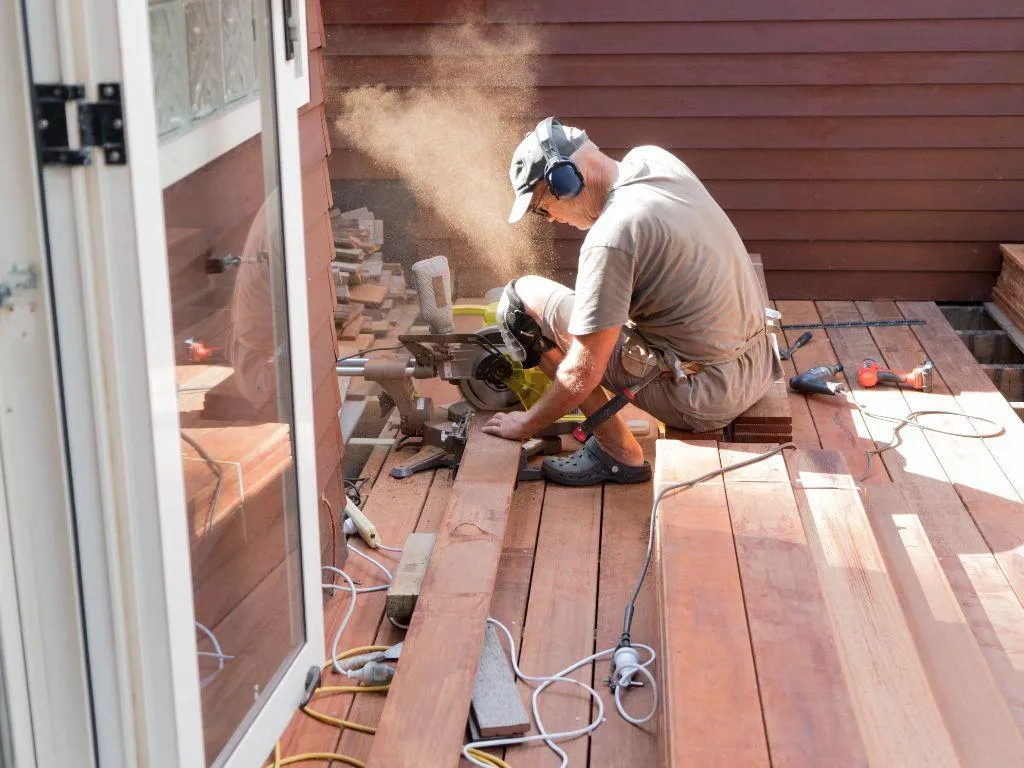Deck repair team working on loose railing and joists