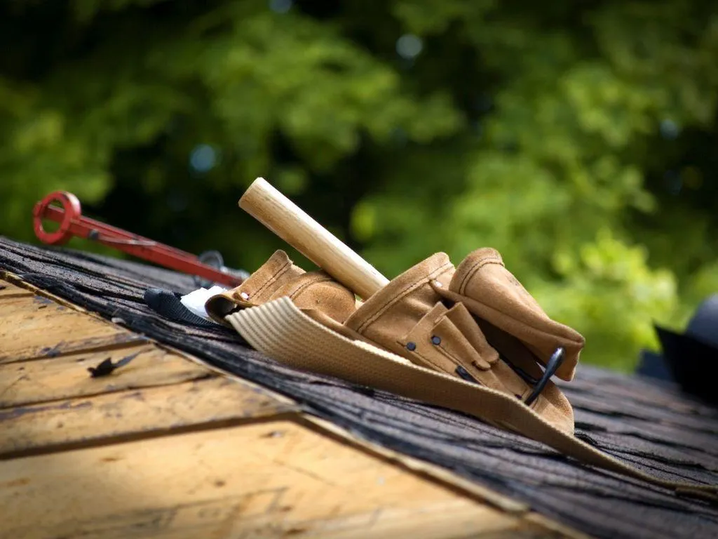 Roofing expert inspecting shingles and flashing on Denton home