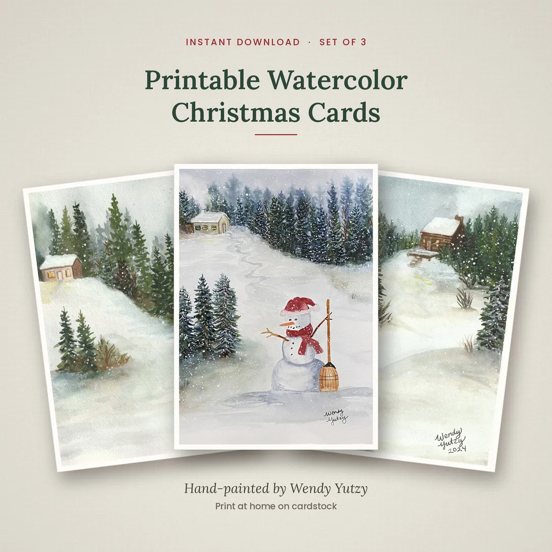 Three hand-painted watercolor Christmas cards with snowy cabins and a snowman