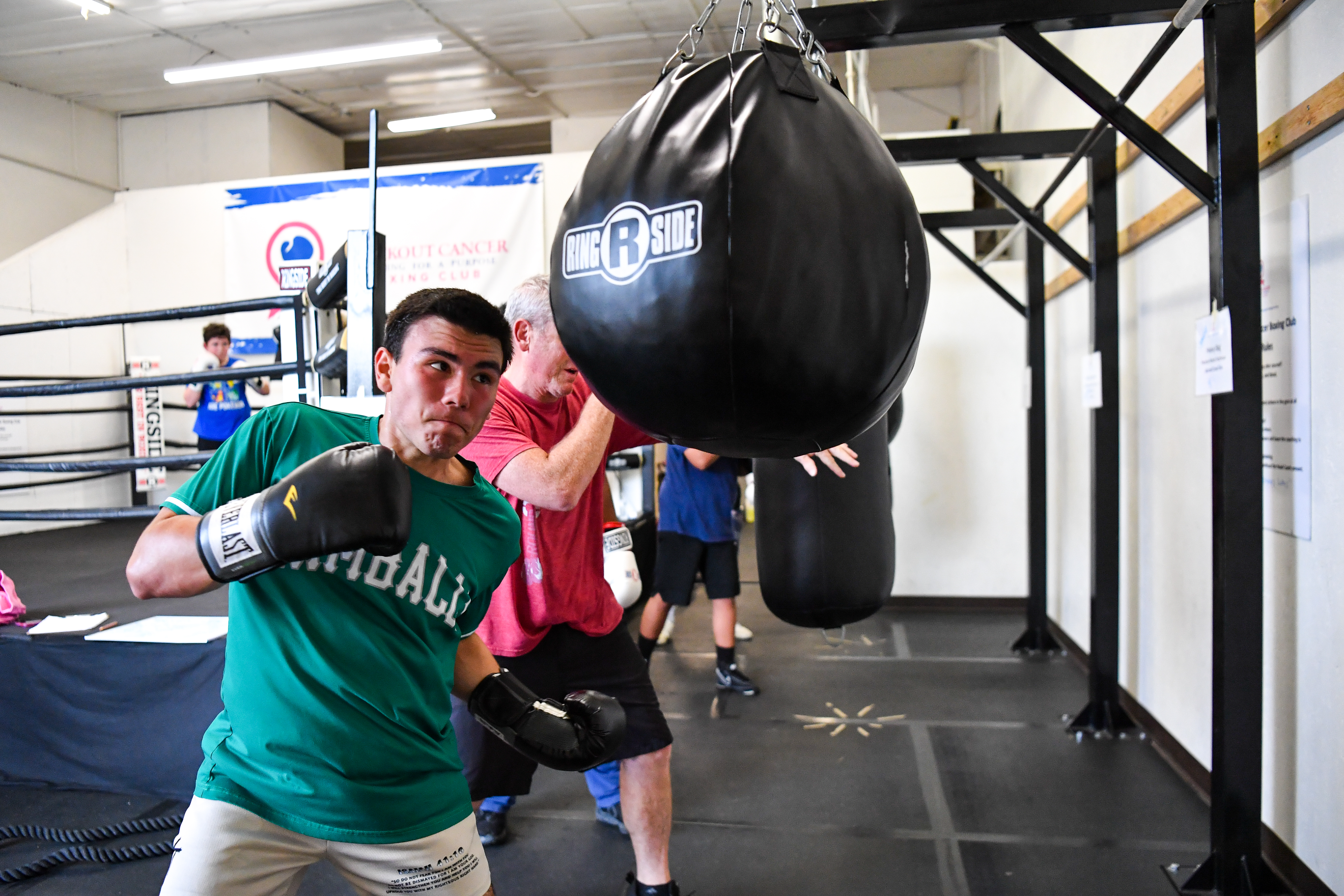 boxing training session in Fort Collins with coach teaching punching technique on speed bag