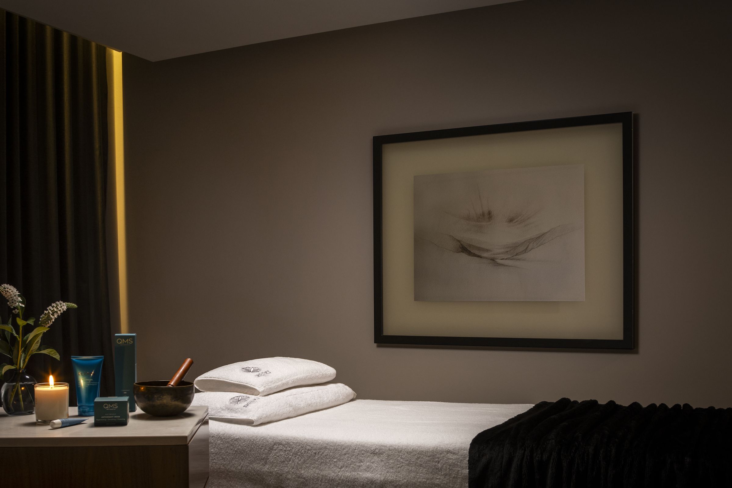 Treatment bed with folded towels in a private room