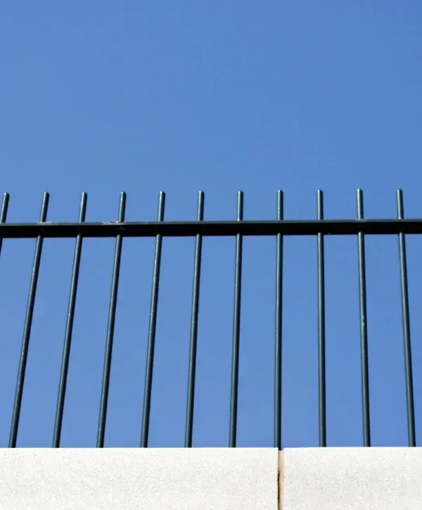 Black metal pool fence installation with clear sky background in College Station.