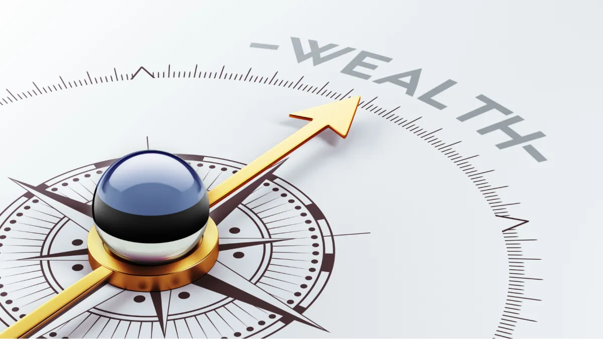 Photo of a compass with the arrow pointing to the word wealth.
