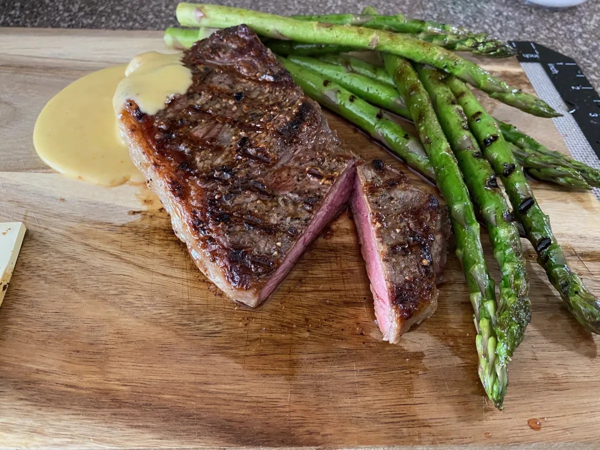 A vibrant plated salmon dish topped with microgreens, served on a copper plate over a crisp white linen. The composition is bright and editorial, highlighting the freshness and artistry of the dish in a 3:2 aspect ratio.