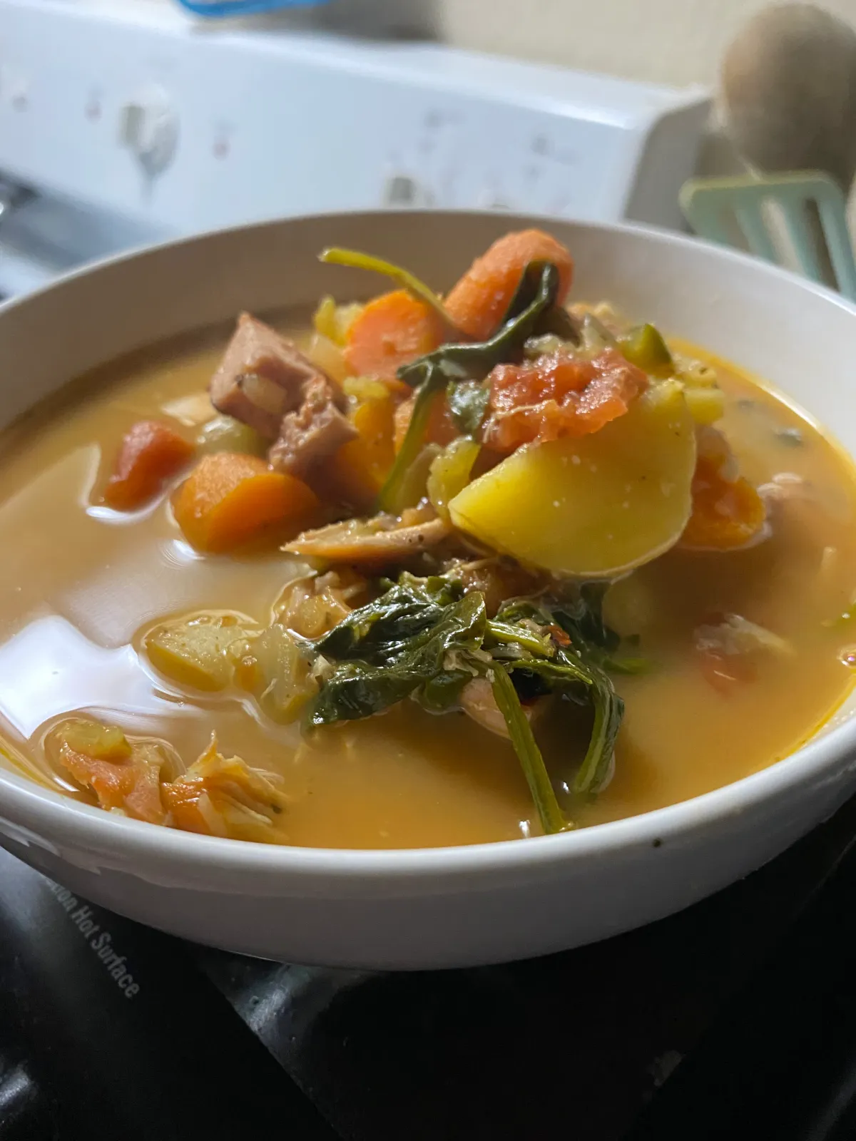 A decadent chocolate dessert garnished with gold leaf, presented on a dark ceramic plate. Dramatic lighting creates rich shadows, emphasizing the dessert's textures and luxury in a 3:2 aspect ratio.