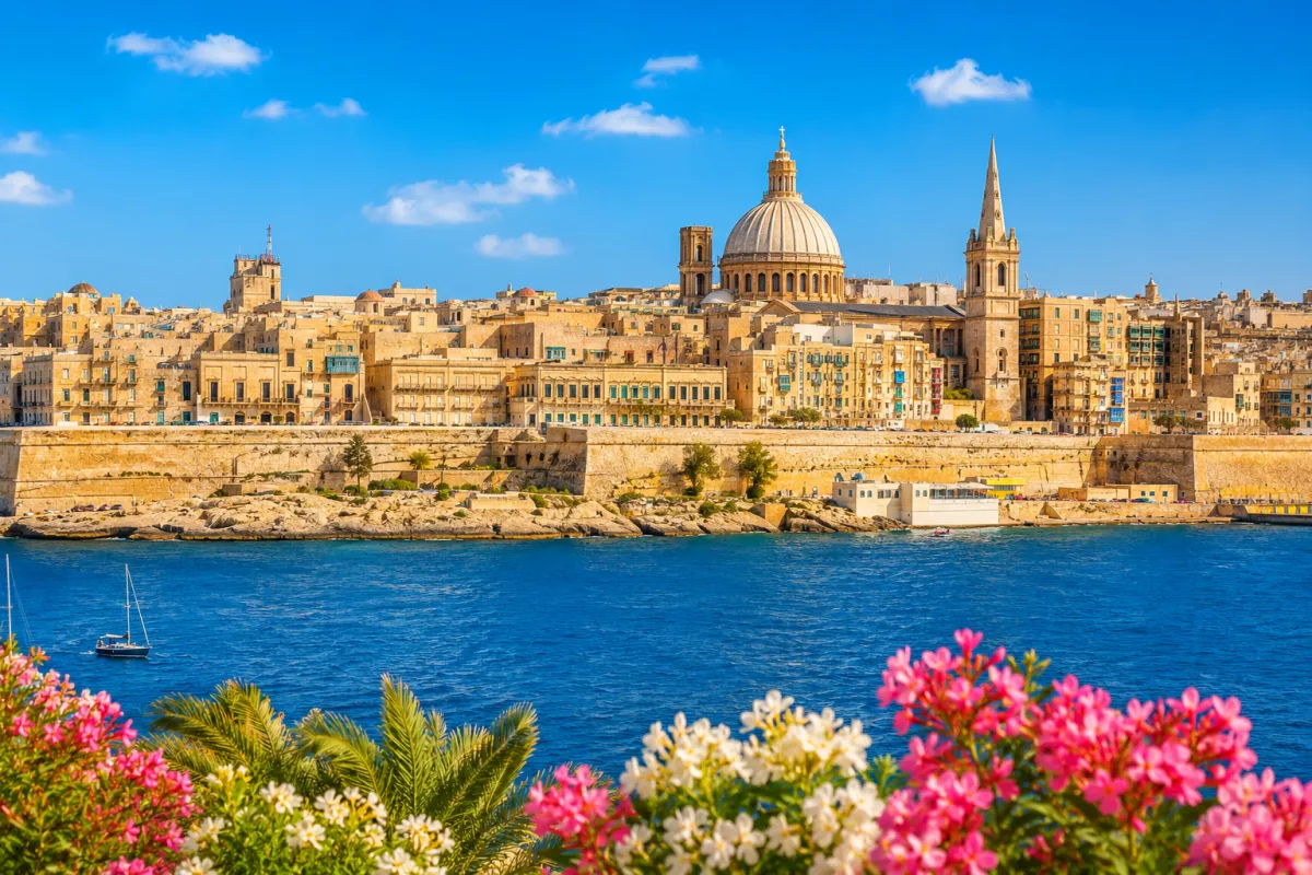 Blick auf die historische Hauptstadt Valletta mit ihren honigfarbenen Sandsteingebäuden, dem türkisblauen Mittelmeer und den beeindruckenden Festungsanlagen unter strahlendem Sonnenschein.