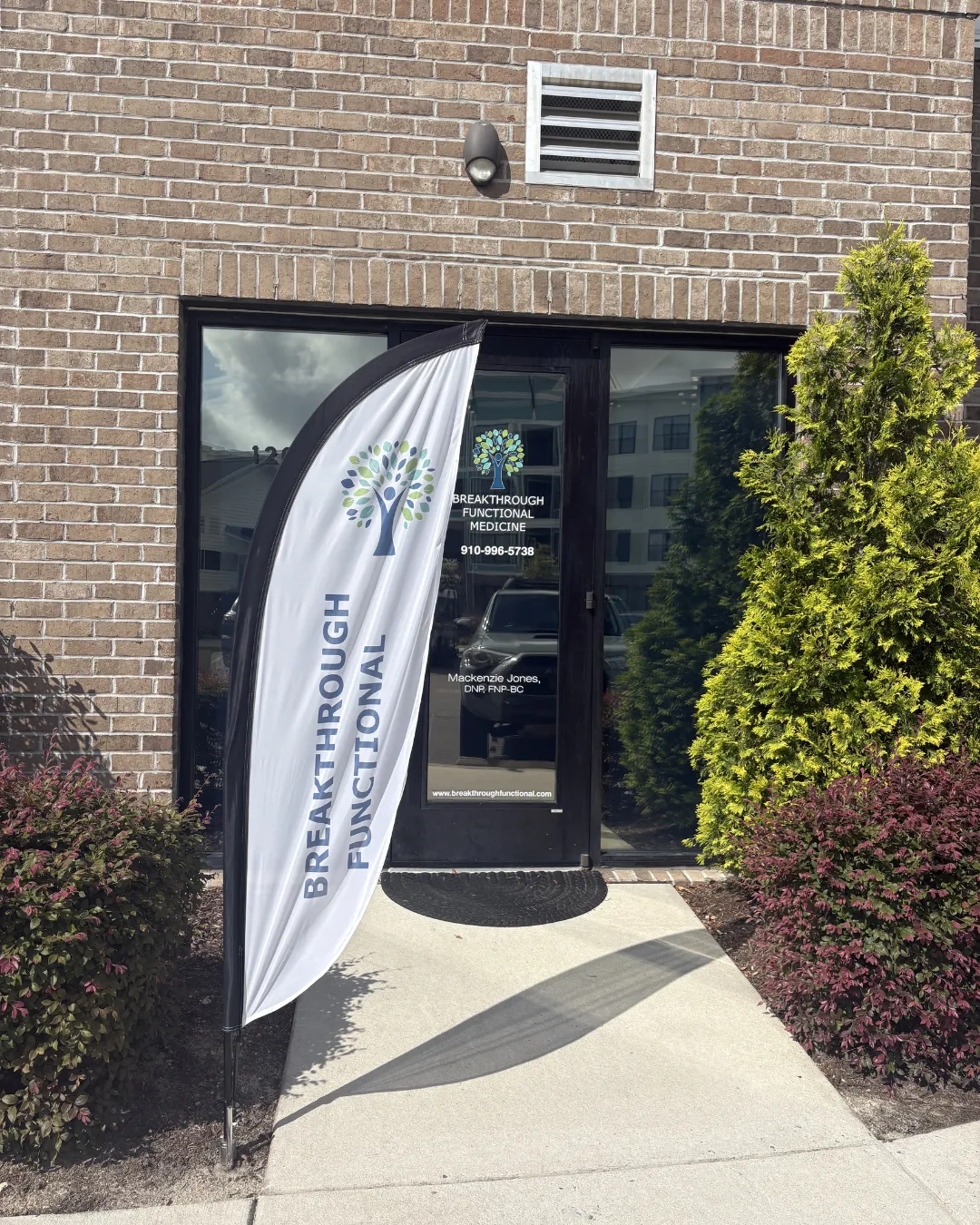 Breakthrough Functional Medicine office entrance with branded flag and signage - Mackenzie Jones DNP FNP-BC