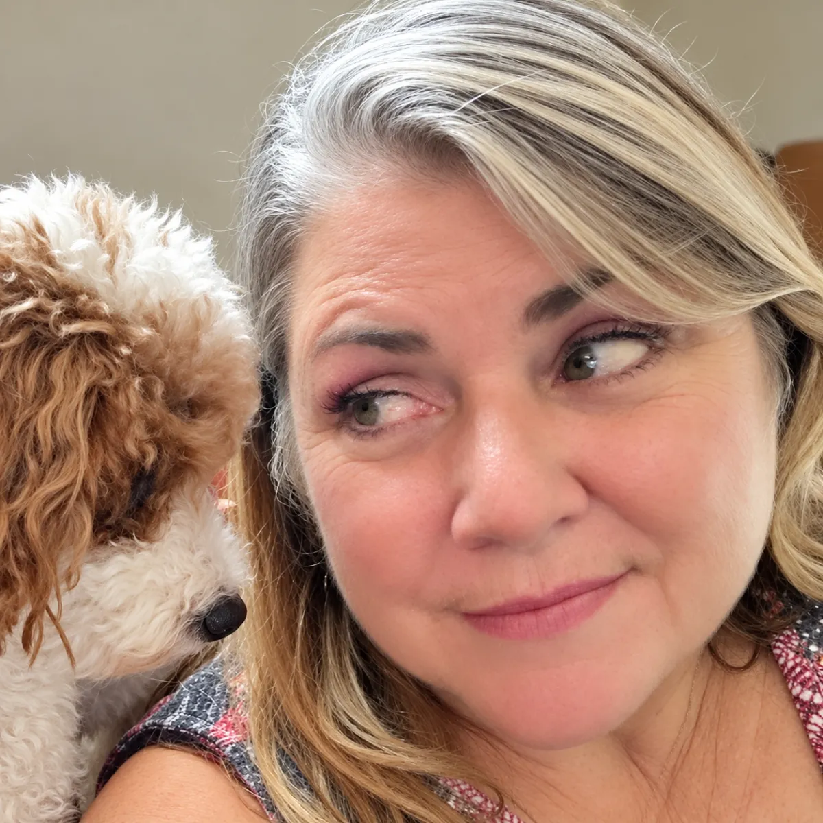 Elisabeth, owner of Your Puppy, My Pad, smiling with her small cream and tan dog
