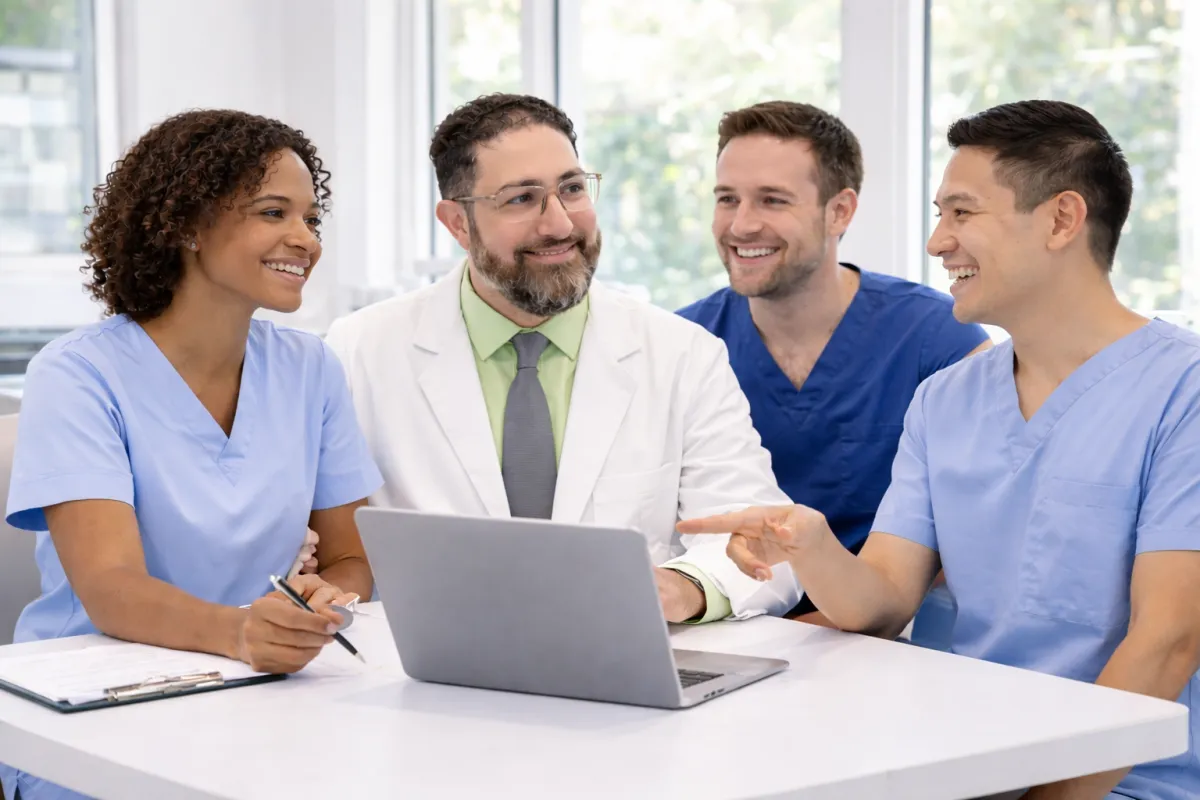 Three diverse female healthcare professionals collaborating in a modern OB-GYN office setting