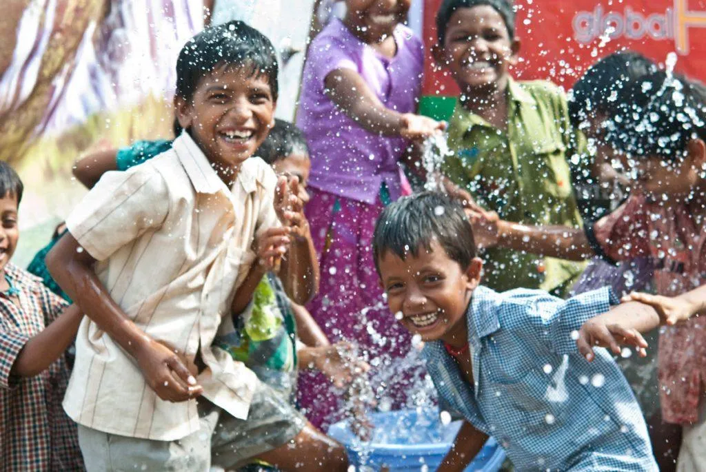 Children splashing water from the bucket 