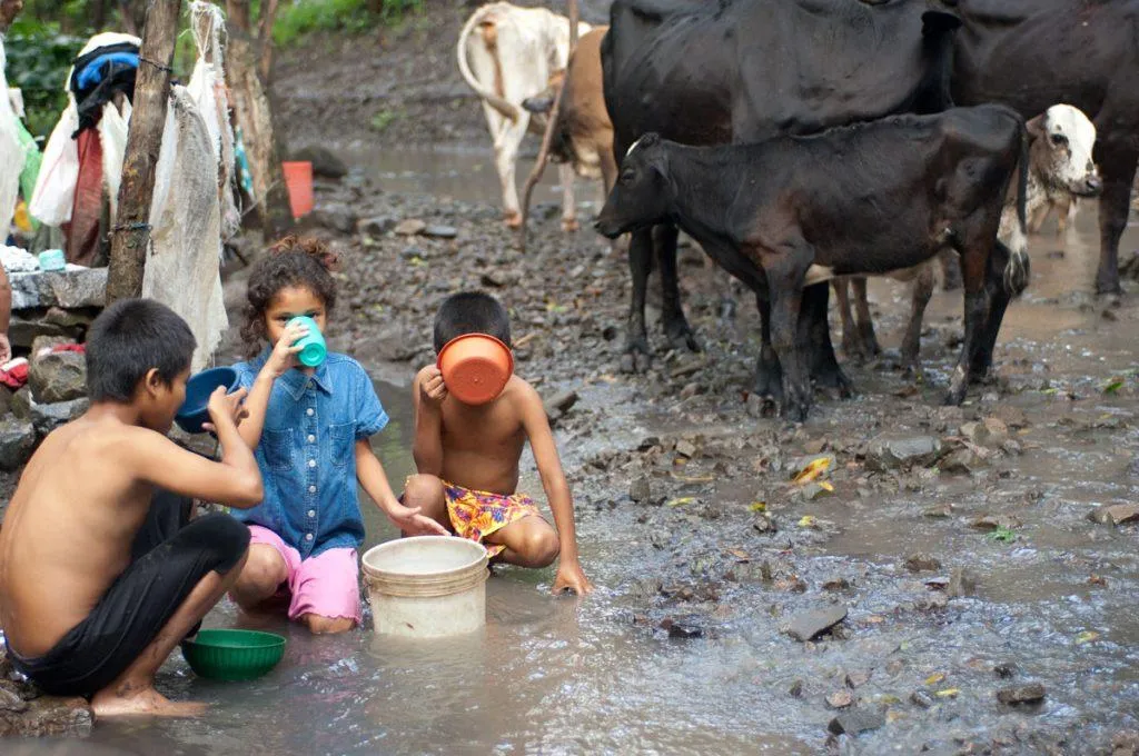 Children drinking water from the bucket