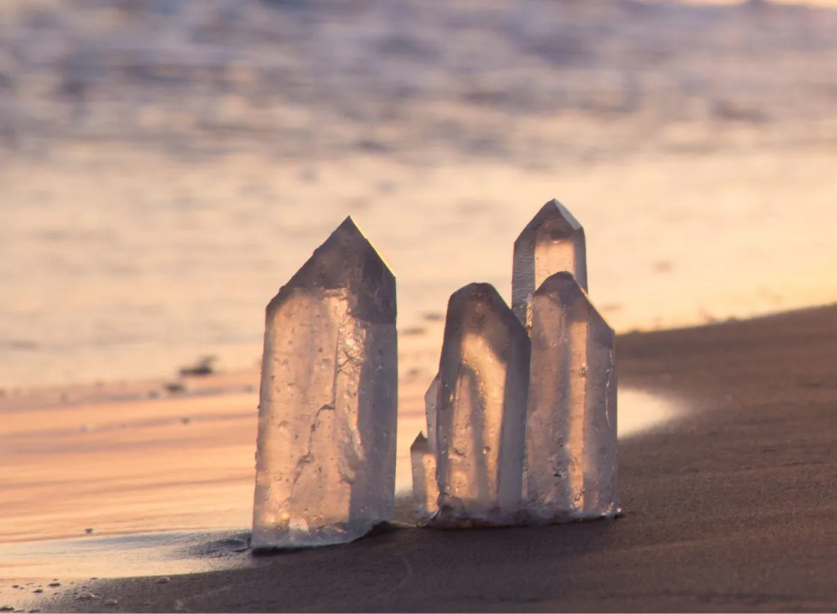 Quarz crystals on the beach, signifying healing and clarity