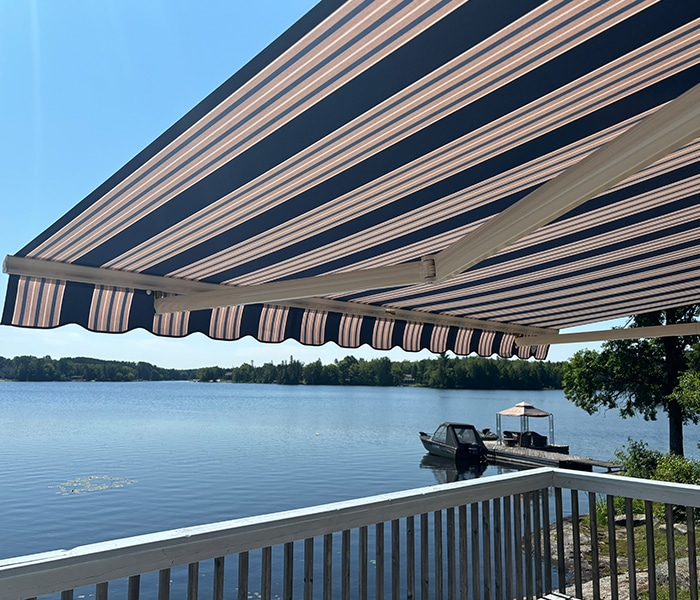Retractable awning over cottage deck with lake view