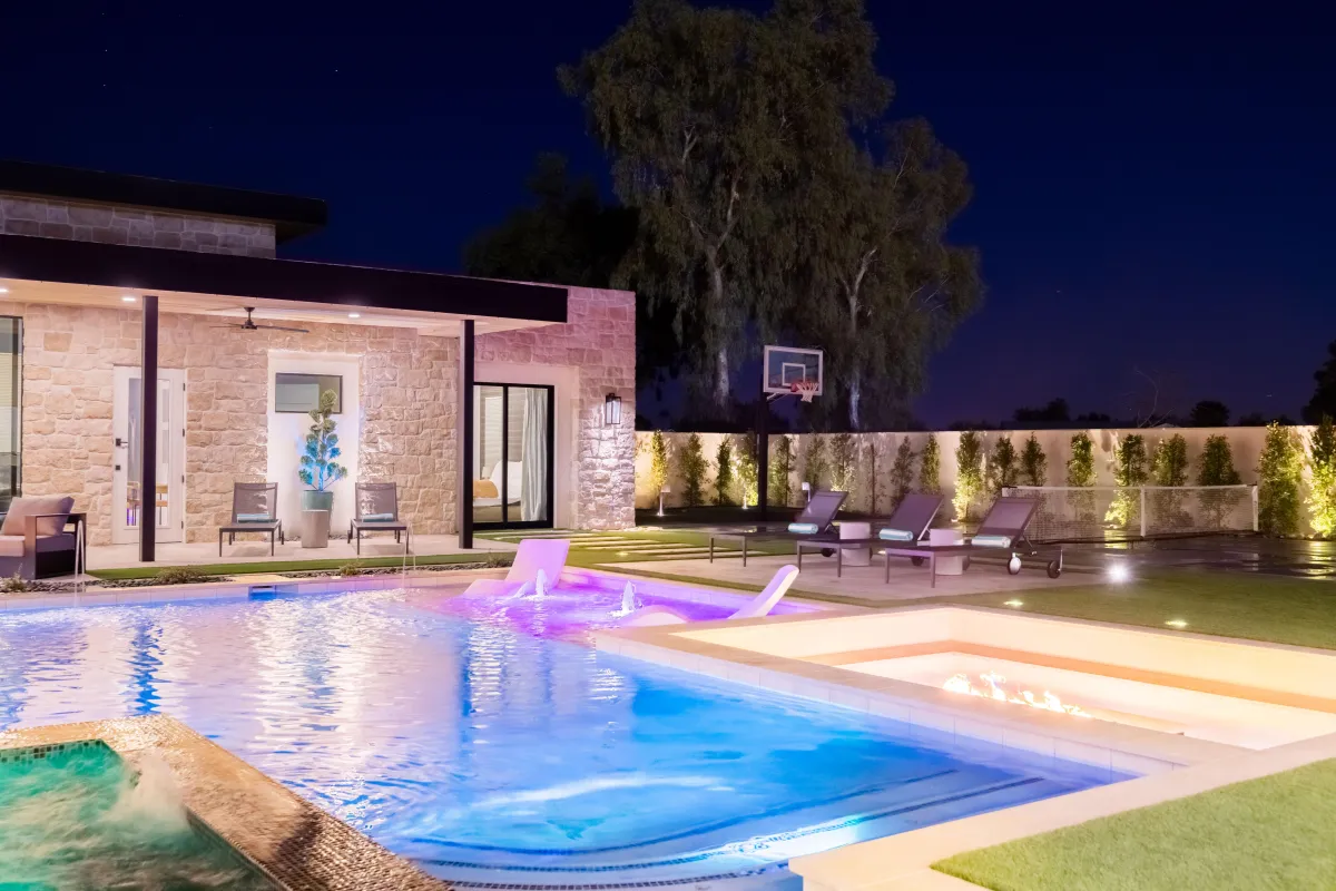 Nighttime view of the illuminated pool with elegant lighting accents