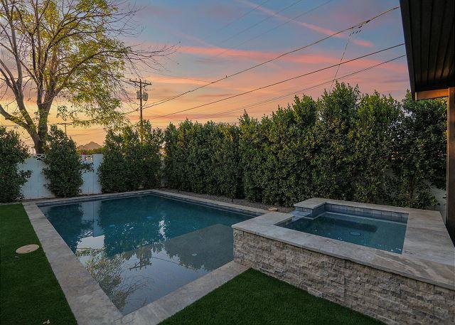 Spacious backyard oasis with multiple seating areas and a BBQ grill